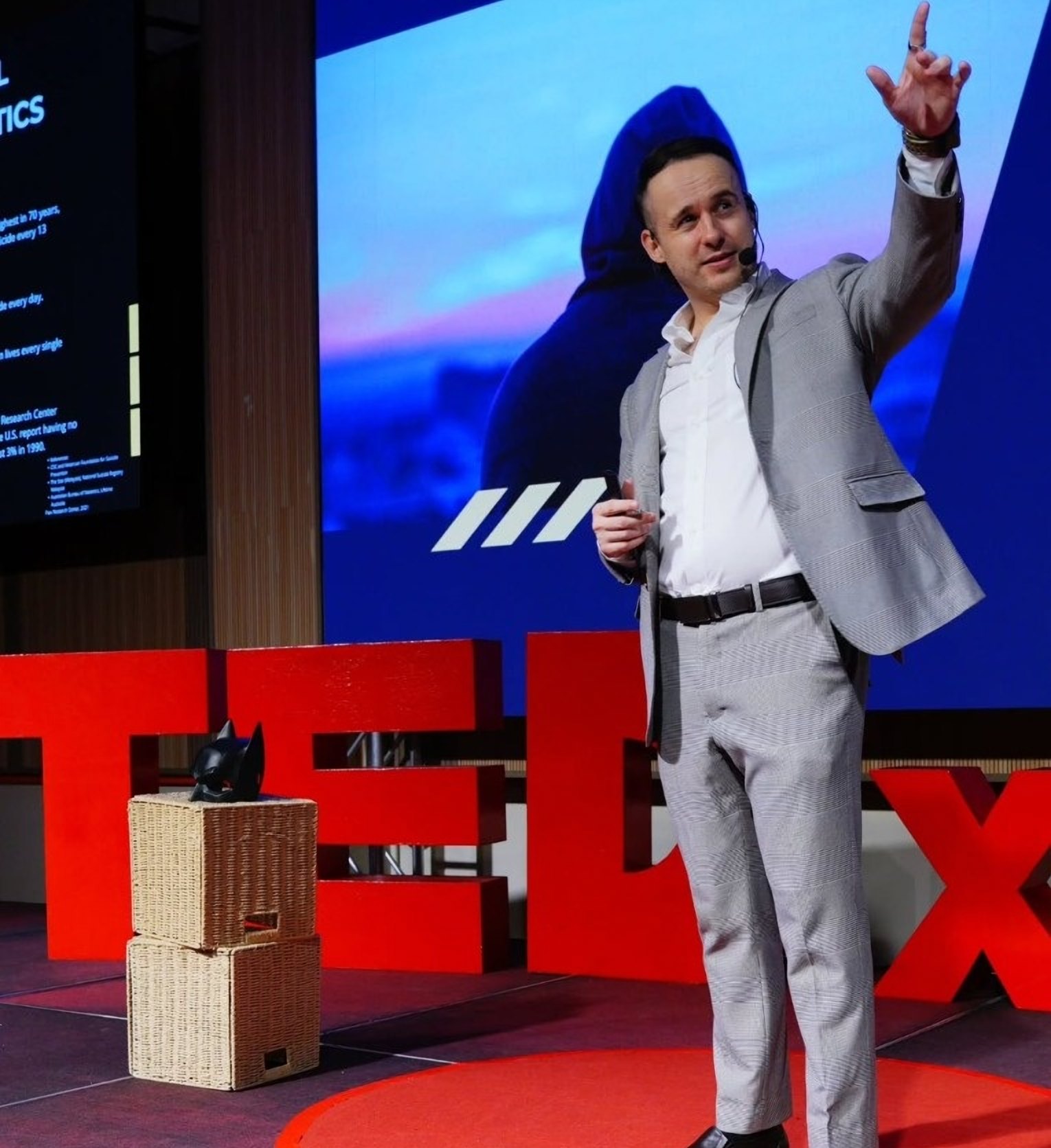 Kain Masters on the TEDx stage, pointing upward